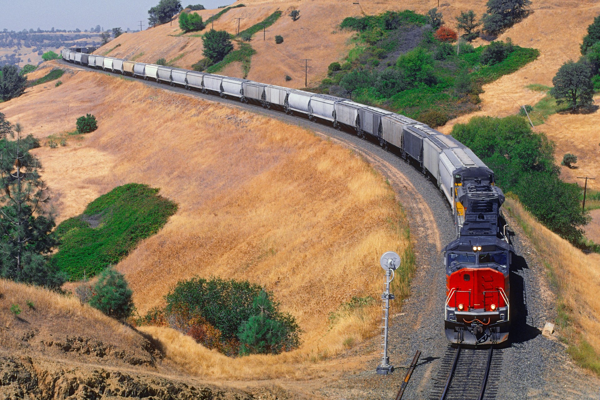 Heavy grain train climbing through hills