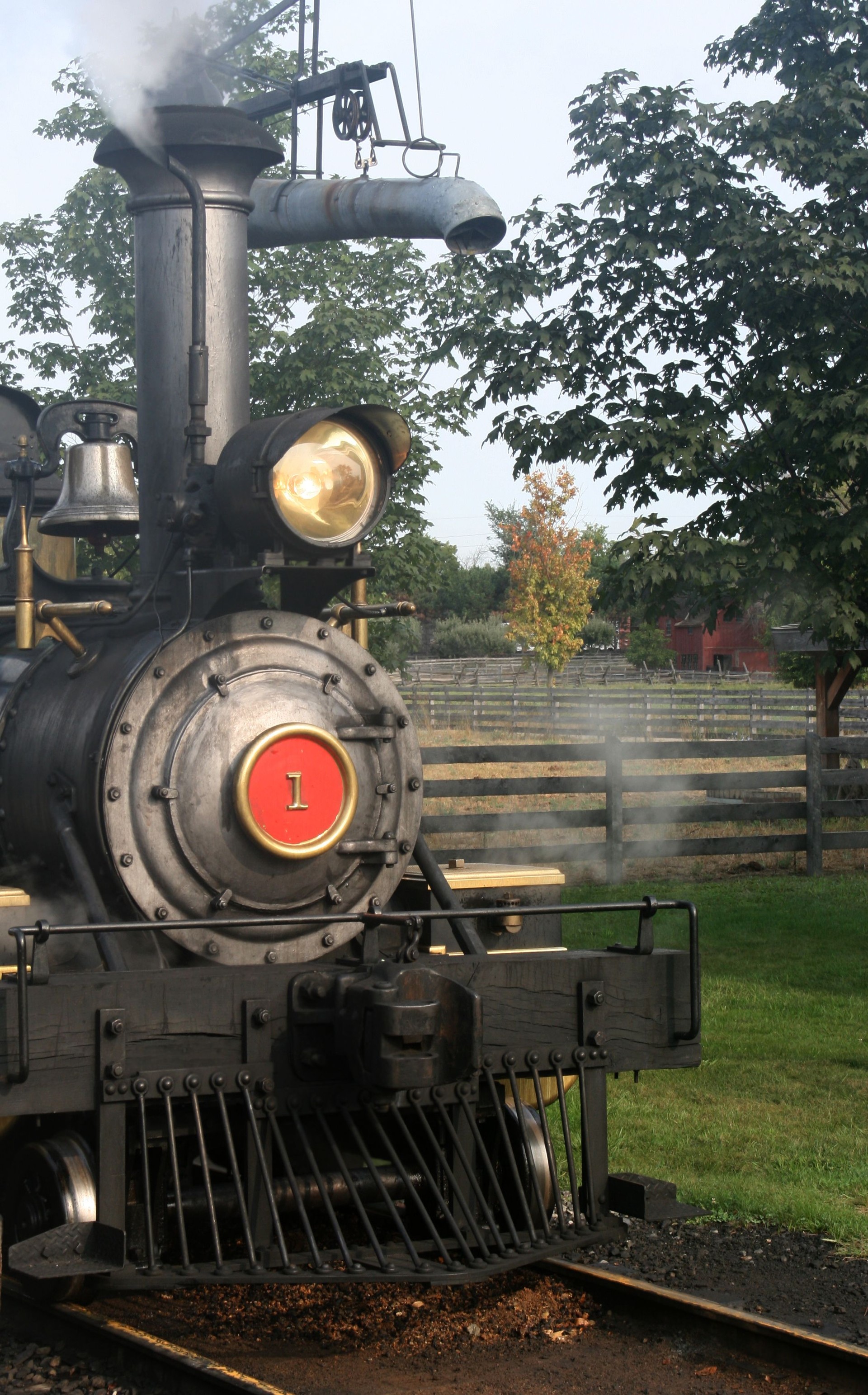 Early 1900's steam locomotive runs thru farmland in Michigan.